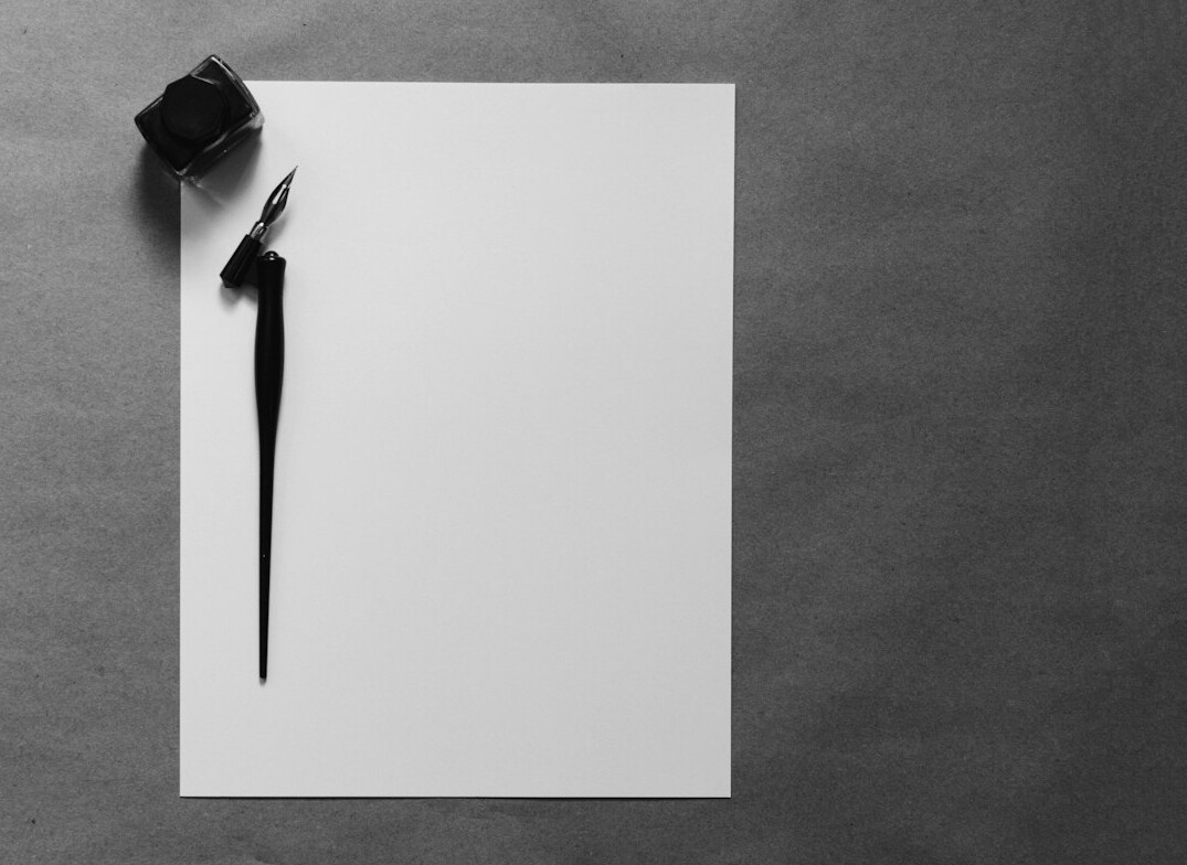 Old letters and an antique fountain pen on a wooden table