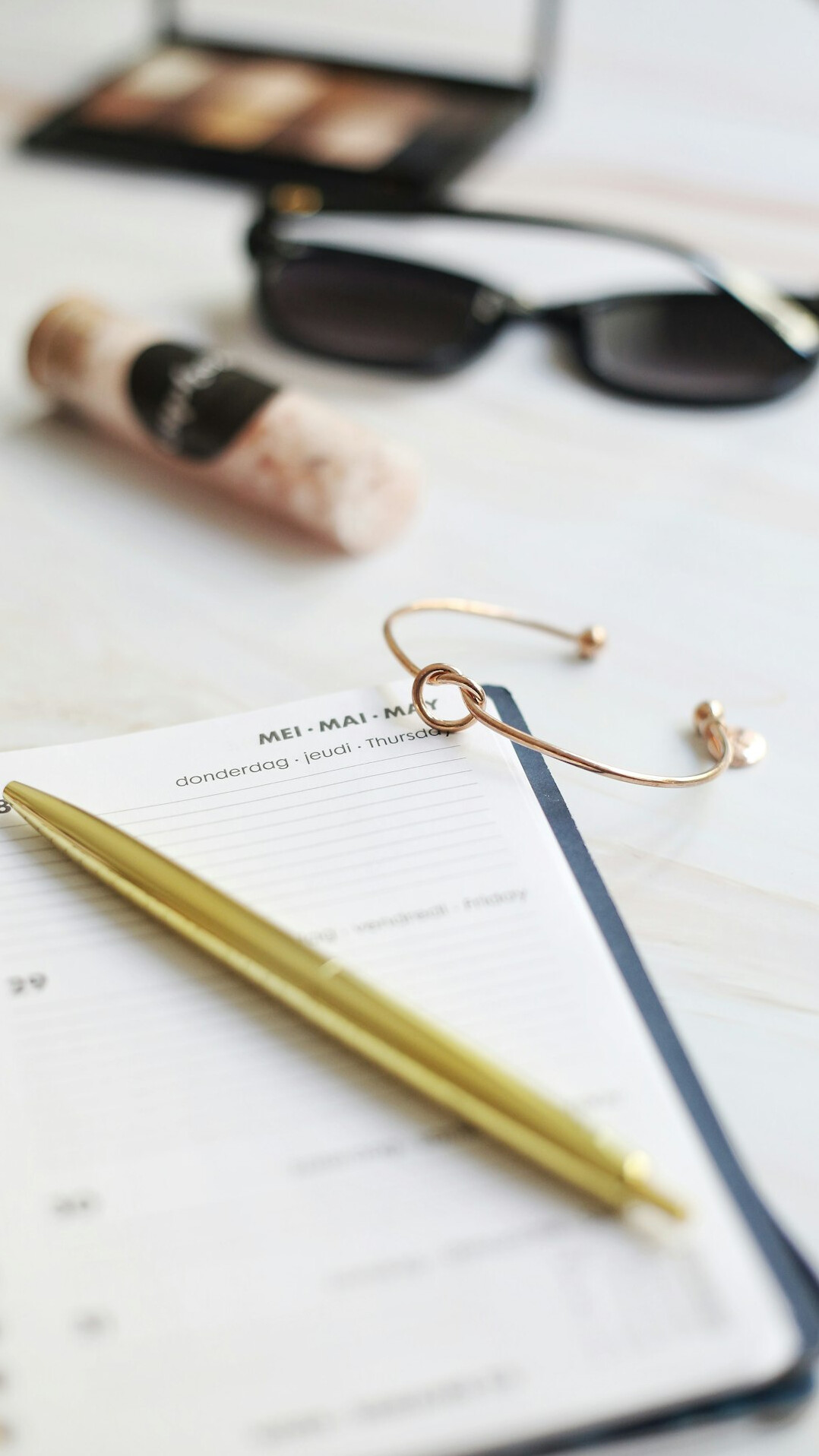 Detective notebook, magnifying glass and fountain pen on an old wooden desk